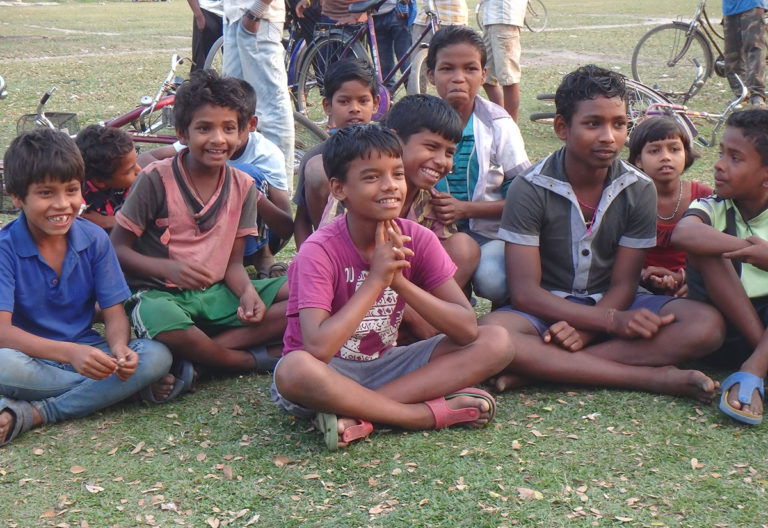 Des enfants d'Inde sont assis par terre et sourient | Terre des Hommes Suisse