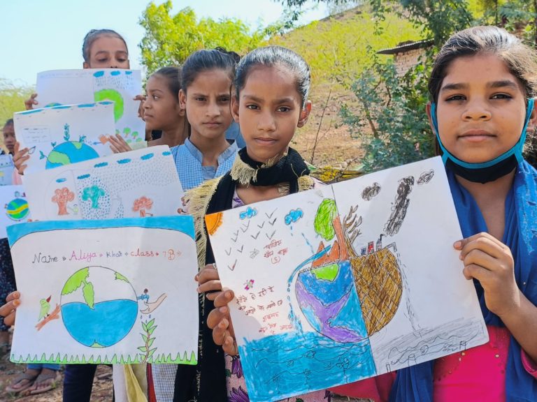 Plusieurs jeunes filles montrent leurs dessins en lien avec le réchauffement climatique en Inde