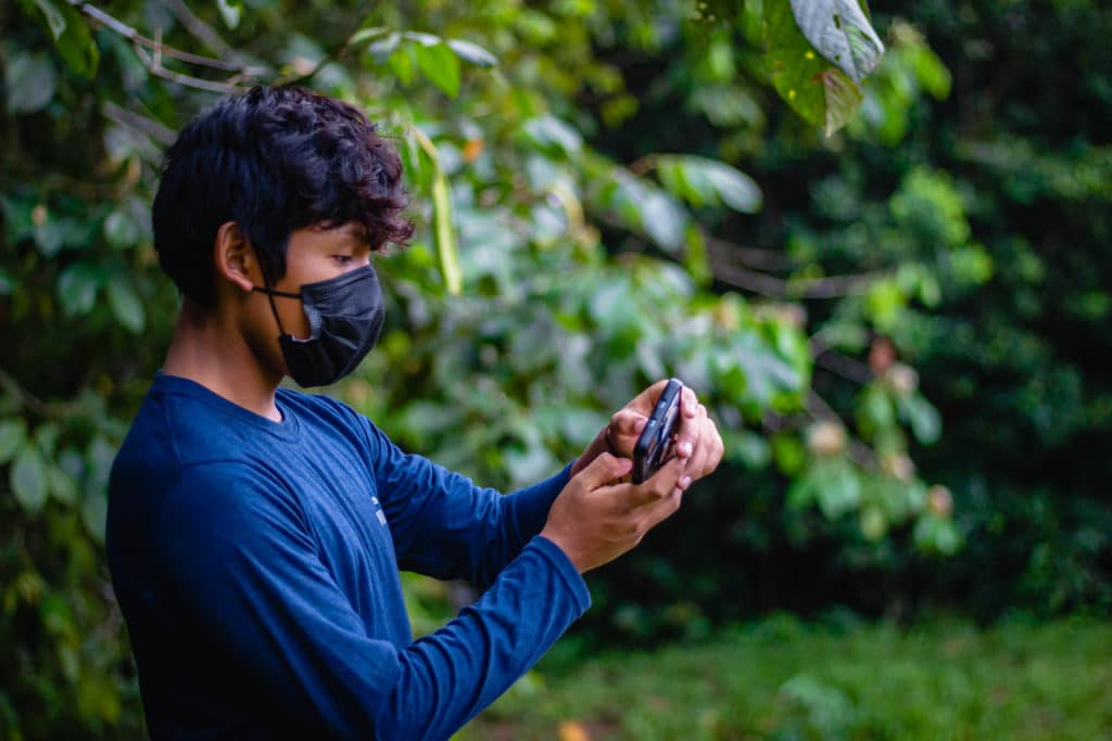 Un jeune avec son smartphone semble prendre en photo quelque chose