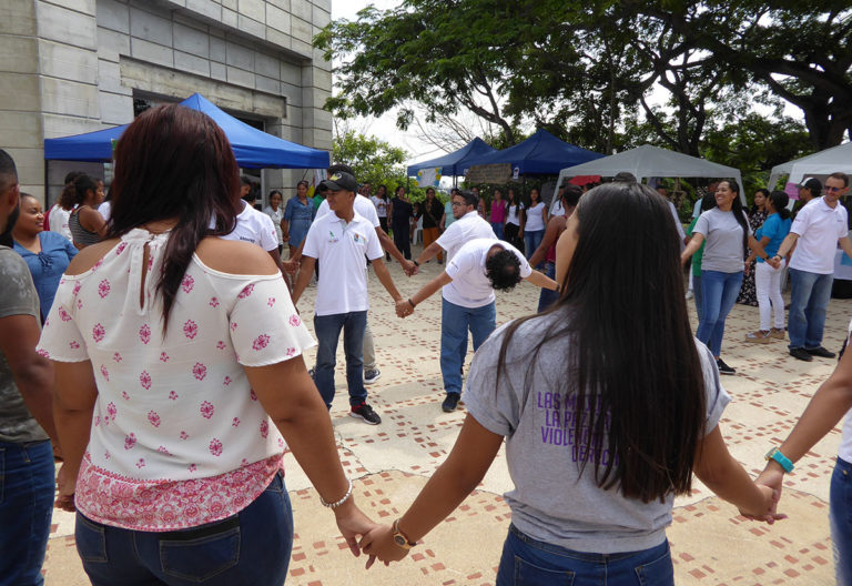 Des jeunes se tiennent par la main sur une place publique en Colombie