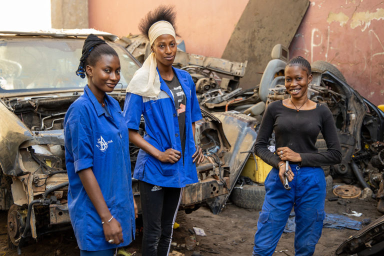 Trois jeunes adolescentes du Sénégal devant une voiture