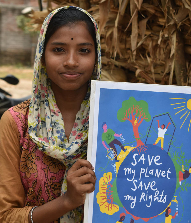 Une jeune fille avec l'affiche de "Save my planet, Save my rights" en Inde