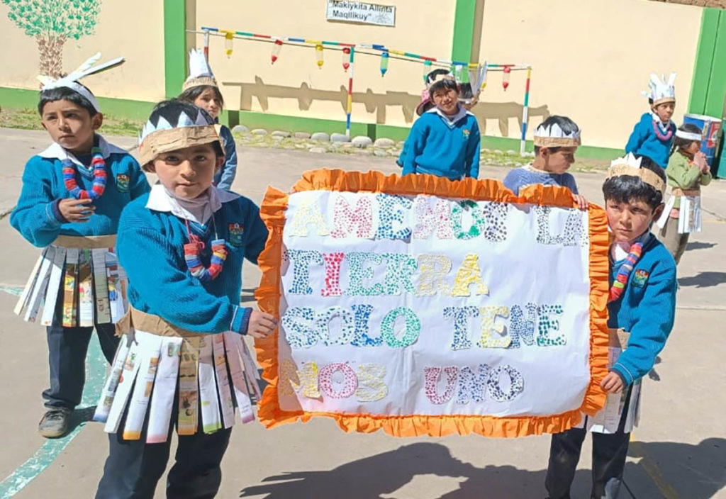 Des enfants avec des pancartes faites en matériel recyclable