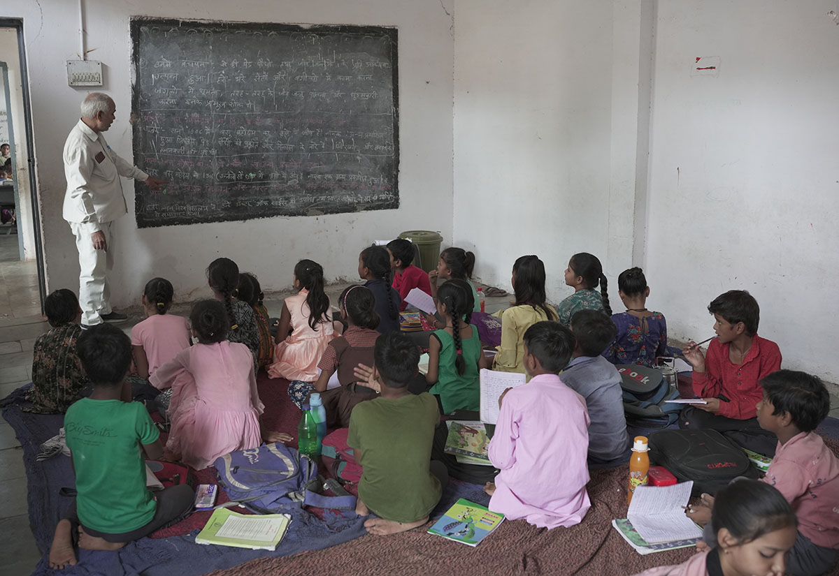 Un prof donne un cours en Inde face à une salle d'enfants